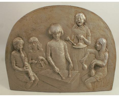 A metal plaque, with embossed decoration of children playing percussion instruments, 13ins x 17.5ins