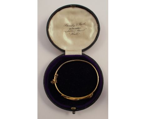 A hinged serpent bangle, stamped '15', with cabochon set eyes, internal diameter 5.6cm , with original case