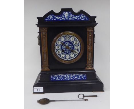 A late Victorian black slate cased mantel clock with applied, decoratively cast mounts and blue and white painted ceramic ins