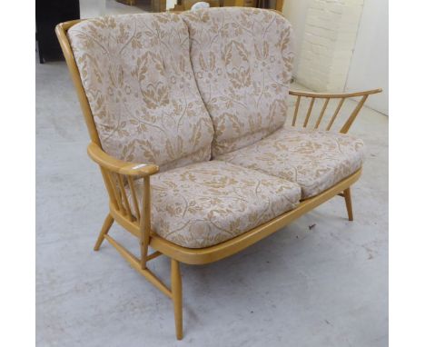 An&nbsp;Ercol blonde beech and elm framed settee with a spindled, level back and open arms, raised on elliptically turned leg