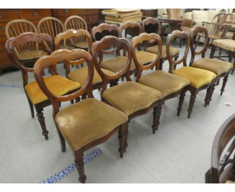 A set of ten mid Victorian mahogany framed balloon back dining chairs, upholstered in sand coloured fabric, the serpentine fr