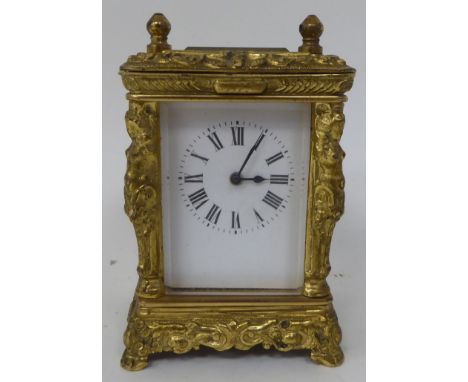 An early/mid 20thC traveller's decoratively cast brass cased carriage timepiece with bevelled glass panels and provision for 