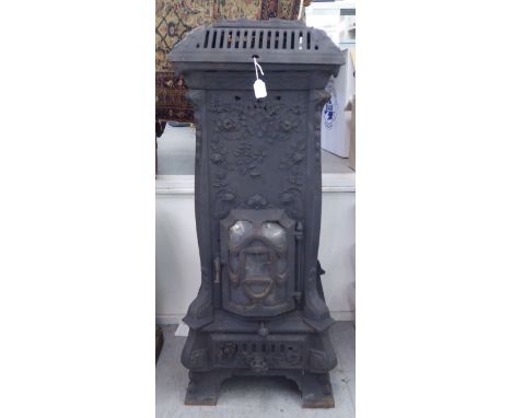 An early 20thC cast iron wood burning stove, decorated in relief with flora, on a bracket plinth&nbsp; 41"h&nbsp; 20"w&nbsp; 