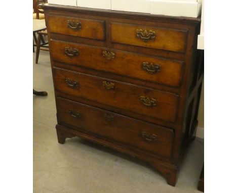 An 18thC country made oak dressing chest, the planked top over two short/three graduated long drawers with brass bail handles