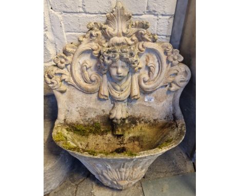 Modern composition weathered garden wall planter decorated with relief flowers and foliage and central mask head cherub. 72cm