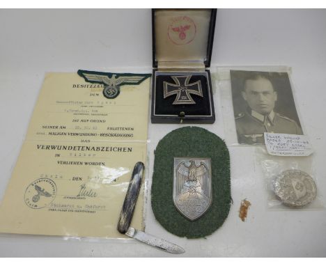 An Unteroffizier Kurt Sporl Grenadier Regiment wound badge with eagle to breast patch, a reproduction Iron Cross with box and