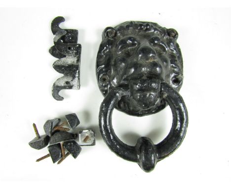 A vintage cast metal door knocker in the form of a lion's mask