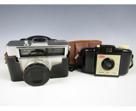 A vintage Kodak Brownie 127 compact film camera together with one other similar