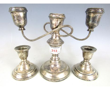 A pair of silver candlesticks together with an electroplate candelabra