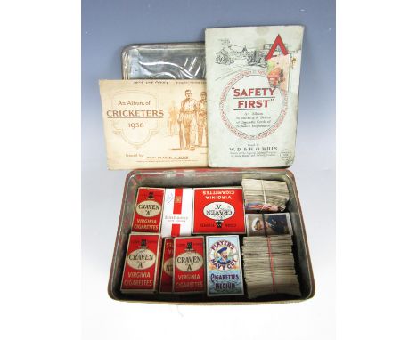 A vintage tin containing a large quantity of vintage cigarette cards