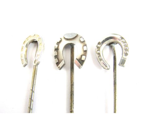 Three white metal stick pins each with a lucky horseshoe terminal, test as silver, 3.7g total