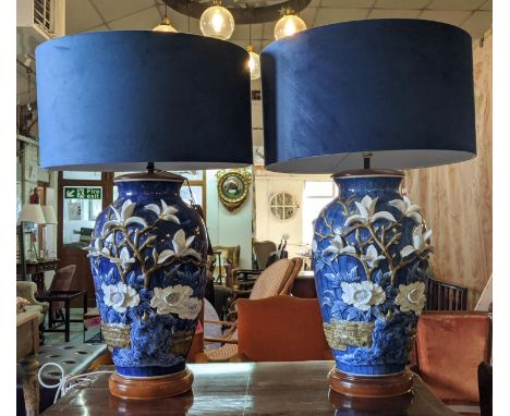 TABLE LAMPS, a pair, 79cm H x 49cm W, blue ceramic with white floral low relief decoration, blue velvet shades. (2) 