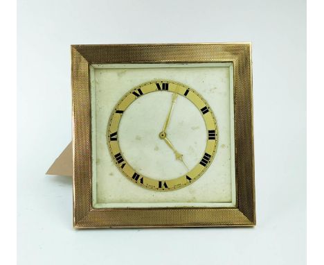 A 9ct TRAVELLING TABLE CLOCK, 12cm H, Birmingham 1927, eight day Swiss movement, engine turned gold surround, square shaped. 