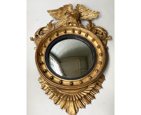 CONVEX WALL MIRROR, 19th century, giltwood circular frame with eagle crest and reeded ebonised slip, 65cm diam. x 89cm H. 
