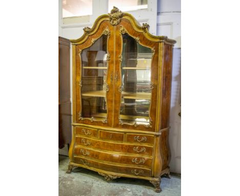 BOMBE BOOKCASE, 219cm H x 149+cm W x 48cm D, 20th century continental walnut and giltwood, with two glazed doors enclosing mi
