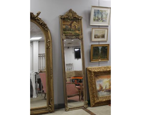 Tall and narrow gilt framed mirror, the upper section decorated with an embroidered cottage and garden panel, 215 cm high, wi