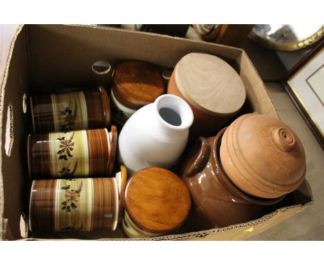 A collection of ceramic containers with covers for kitchen use