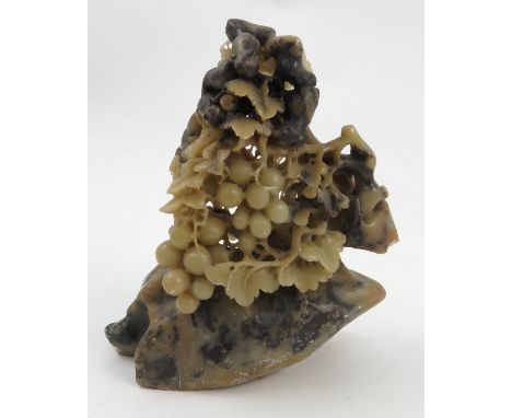 A Chinese soapstone carving, of a boulder topped by a carved and pierced fruiting vine interspersed with squirrels 