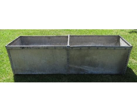 A galvanised iron water trough, with stud decoration and cross bar, length 62ins, width 18.5ins, depth 16ins