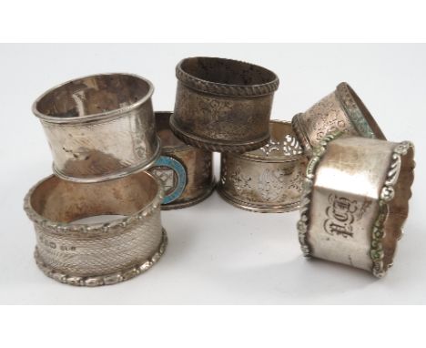 Seven various hallmarked silver napkin rings, to include a pair with engraved decoration, a pierced one and one with enamel r