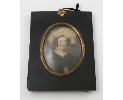 A pair of oval over painted portrait prints, of a woman and a man in 19th century dress, in black rectangular frames with gil