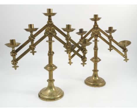 A pair of brass ecclesiastical candlesticks, each stick with five lights and adjustable arms and adjustable stem, engraved wi
