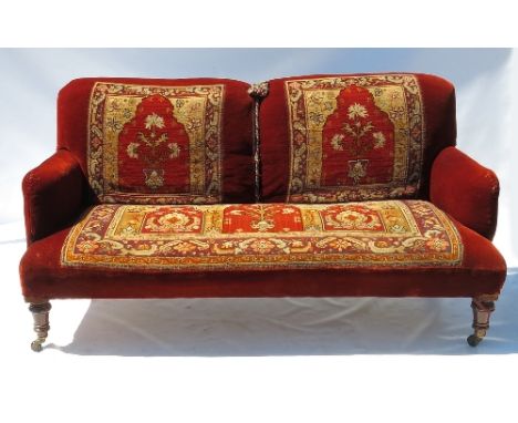 A 19th century sofa, with carpet style decoration, raised on short turned legs, width 63ins 