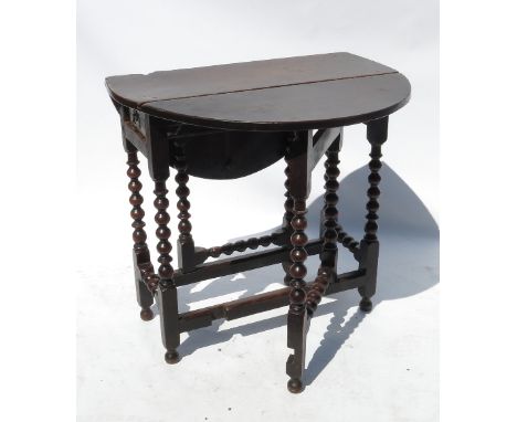 An 18th century oak oval gate leg table, raised on bobbin turned legs, fitted with a drawer to each end, 36ins x 30ins 