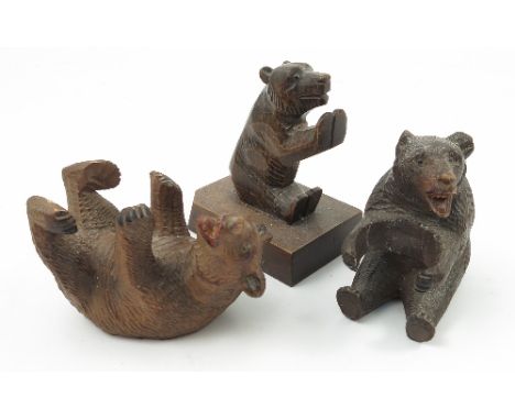 A collection of Black Forest carved bears, to include a bear on a carved inkstand, a desk blotter, bookends, thermometer hold