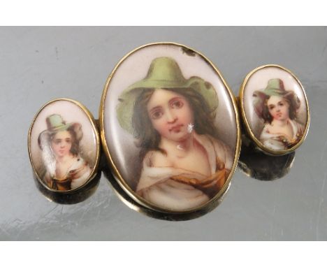 A bar brooch, formed with an oval porcelain plaque flanked by two smaller oval porcelain plaques, all decorated with a portra