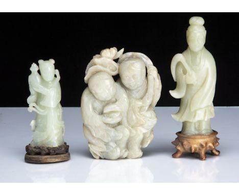 Three Chinese jadeite jade carved figures including a man and lady group, 14cm, a figure of Guanyin on stand, and another fig