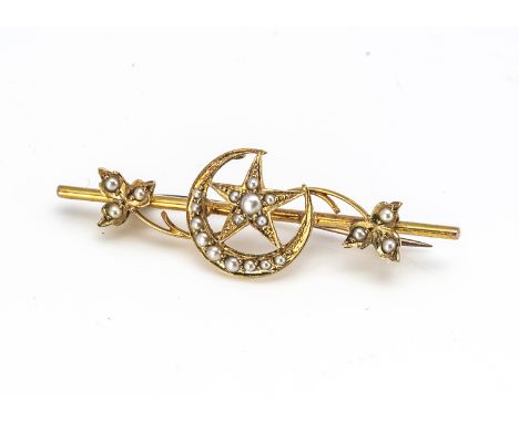 An Edwardian 15ct gold seed pearl set bar brooch, decorated with sickle moon and star with ivy leaves, marked 15ct to reverse