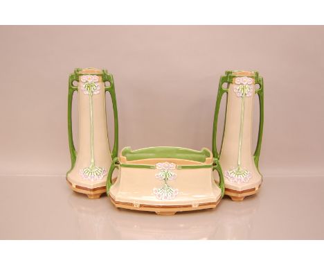 An Art Nouveau period Eichwald pottery three piece garniture, pair of vases 32cm high, with a planter, numbered 7719/4, purch