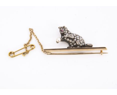 An Edwardian diamond encrusted pussy cat bar brooch, the rose cut diamonds set in silver with ruby cabochon eyes and seed pea