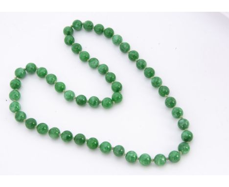 A string of jadeite jade knotted spherical beads, each approximately 12mm diameter, 35cm together, 122g (suggest dyed)