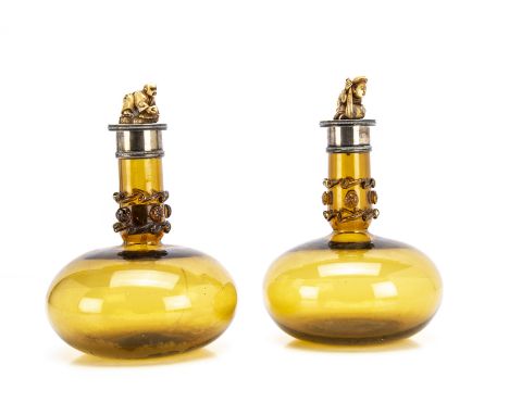A pair of early 20th century amber glass and silver mounted decanters, 21cm high, flared bulbous lowers with applied trails a