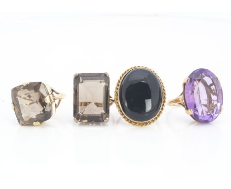 A collection of four 9ct gold gem set dress rings, the large amethysts and smoky quartz set in claw settings together with an