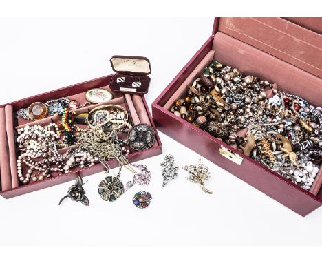 A collection of costume jewels in a red case, hinged lid opens to reveal a collection of jewels including a Miracle Celtic pe