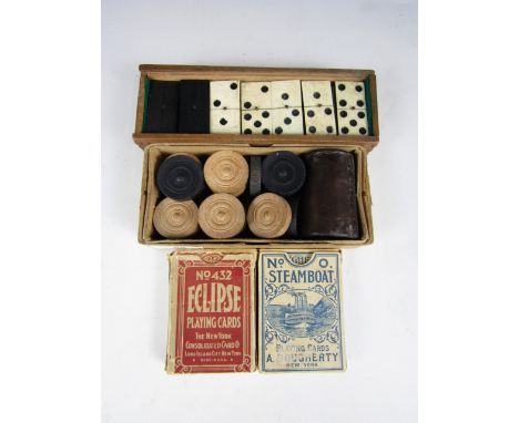 A set of 19th Century bone and ebony dominoes, together with draughts pieces and playing cards etc.