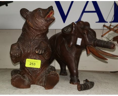 An early 20th century Black Forest carved wood bear tobacco jar 21cm and a later carved elephant with articulated trunk 