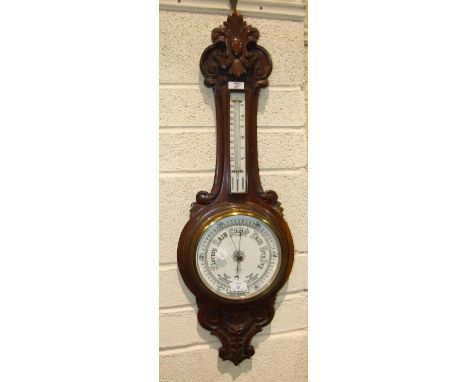 W H May, Nottingham, a carved stained mahogany banjo aneroid barometer/thermometer, 90cm high.