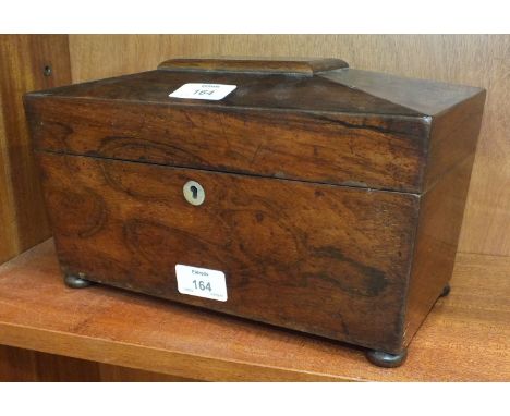 A 19th century rosewood tea caddy of sarcophagus shape, the interior with two containers and mixing bowl aperture, on bun fee