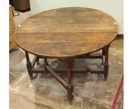 An antique oak gate-leg drop-leaf table with fitted end drawer, on turned legs, 146.5 x 120cm.