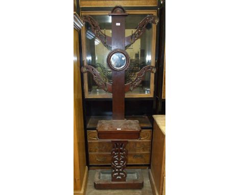 A Late-Victorian stained mahogany four-branch hall stand with central circular mirror, glove box and stick stands, 81cm wide,