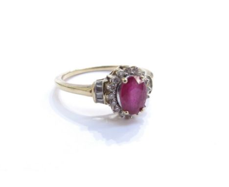 A ruby and diamond cluster ring, the central oval ruby framed by diamonds with diamond set shoulders, stamped 10k. Size O, 2.