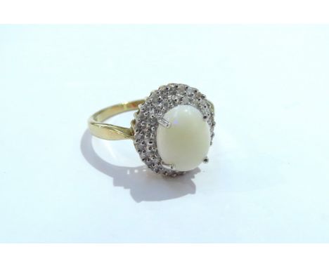 A 9ct gold opal and diamond cluster ring, the central oval opal 10mm x 7mm framed by two rows of small diamonds. Size T/U, 3.