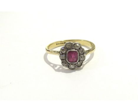 An 18ct gold ruby and diamond cluster ring. Size K, 2g