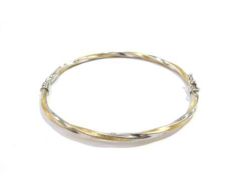 A two tone gold twisted bangle, stamped 750, 5.1g