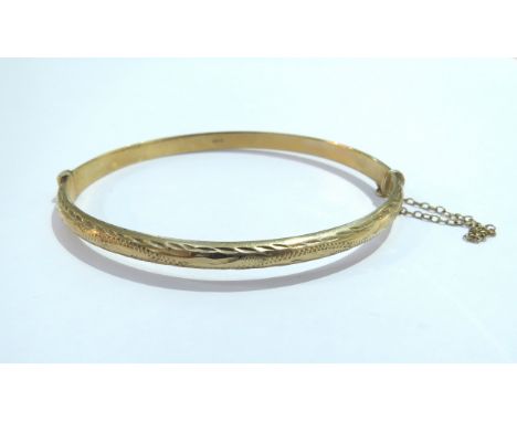 A 9ct gold  hinged bangle with bright cut decoration, 6g
