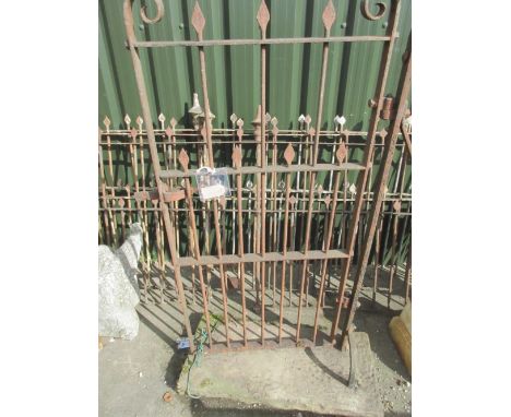 Three lengths of cast iron fencing, plain uprights with spearhead finials, with a matching gate on stone base, L500cm H117cm,